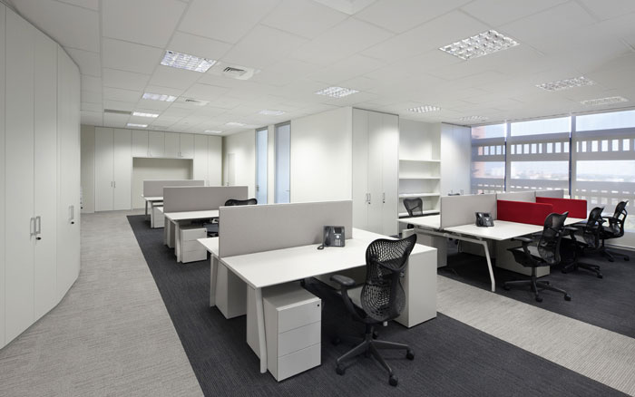 Open space uffici con postazioni di lavoro e finiture moderne